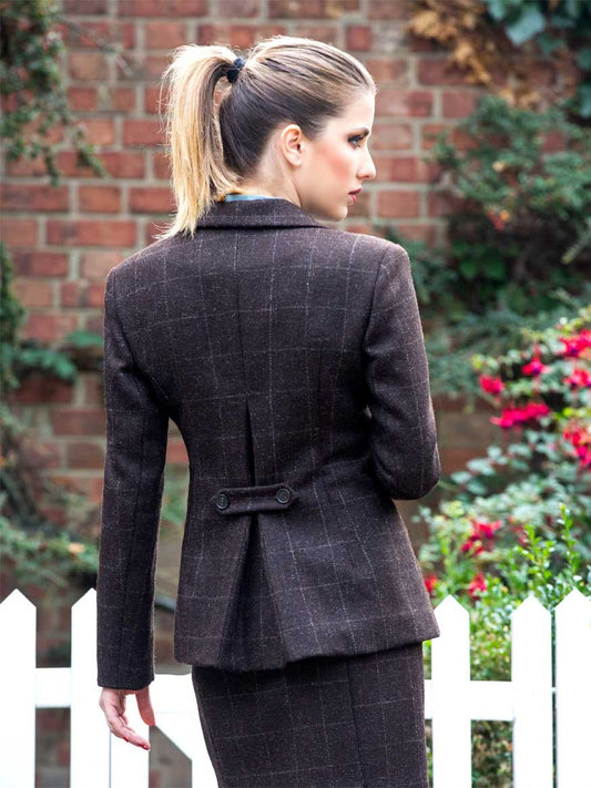 Back view of jacket showing vent, pleat and detachable belt with two horn buttons.