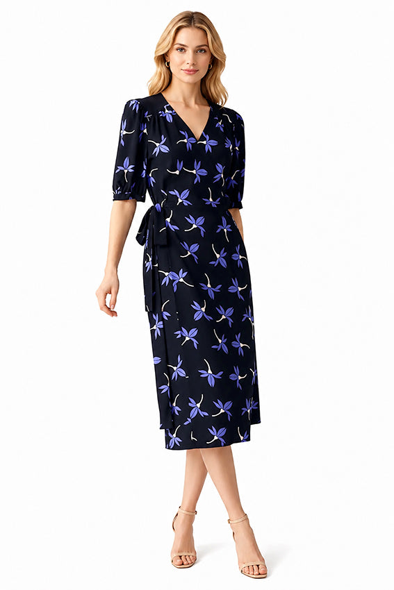 Designer floral evening dress with V-neckline and soft puff sleeves styled on a blonde fashion model in a studio setting.