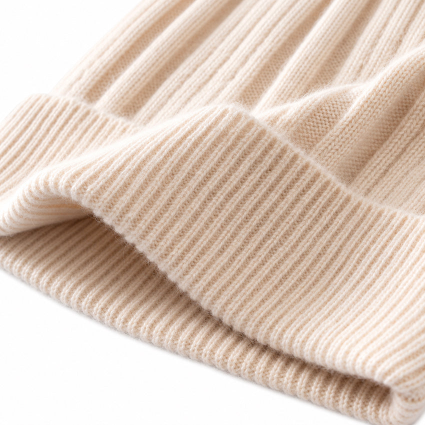 Close-up of cream pure cashmere beanie showing the ribbed cuff and soft cashmere texture
