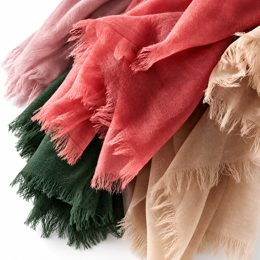 Close-up of Moda de la Maria lightweight pure cashmere shawls showing fine woven texture and delicate fringed edges