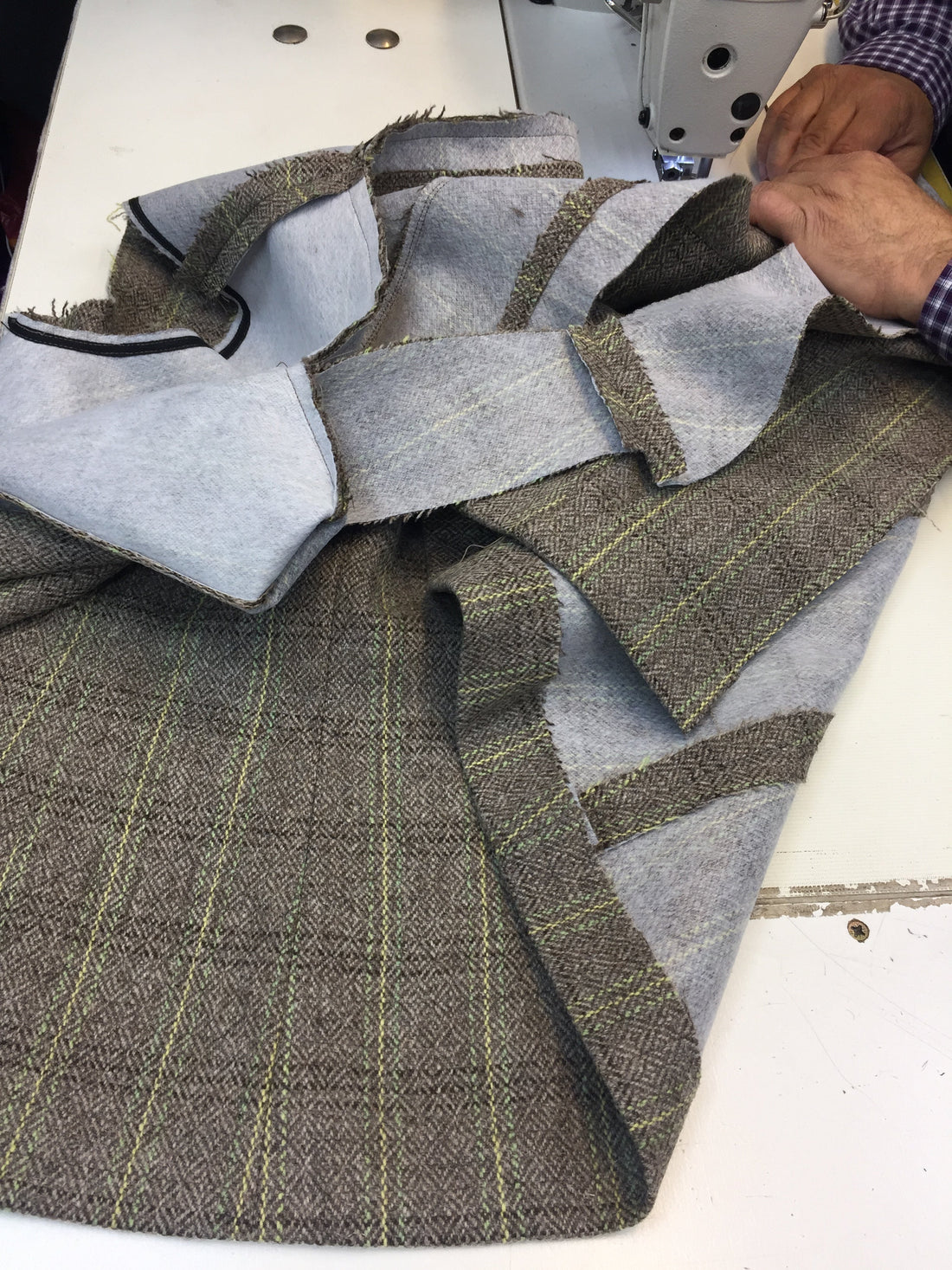 Close-up of two hands carefully stitching a handcrafted Moda de la Maria jacket, showcasing luxury tailoring, couture finishing, and slow fashion craftsmanship.