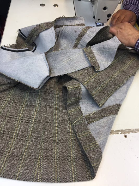 Close-up of two hands carefully stitching a handcrafted Moda de la Maria jacket, showcasing luxury tailoring, couture finishing, and slow fashion craftsmanship.