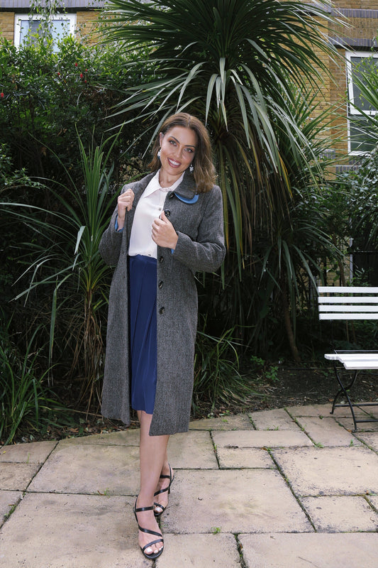 Woman wearing a handcrafted organic wool tweed coat and silk skirt representing timeless luxury fashion and natural fabric craftsmanship.