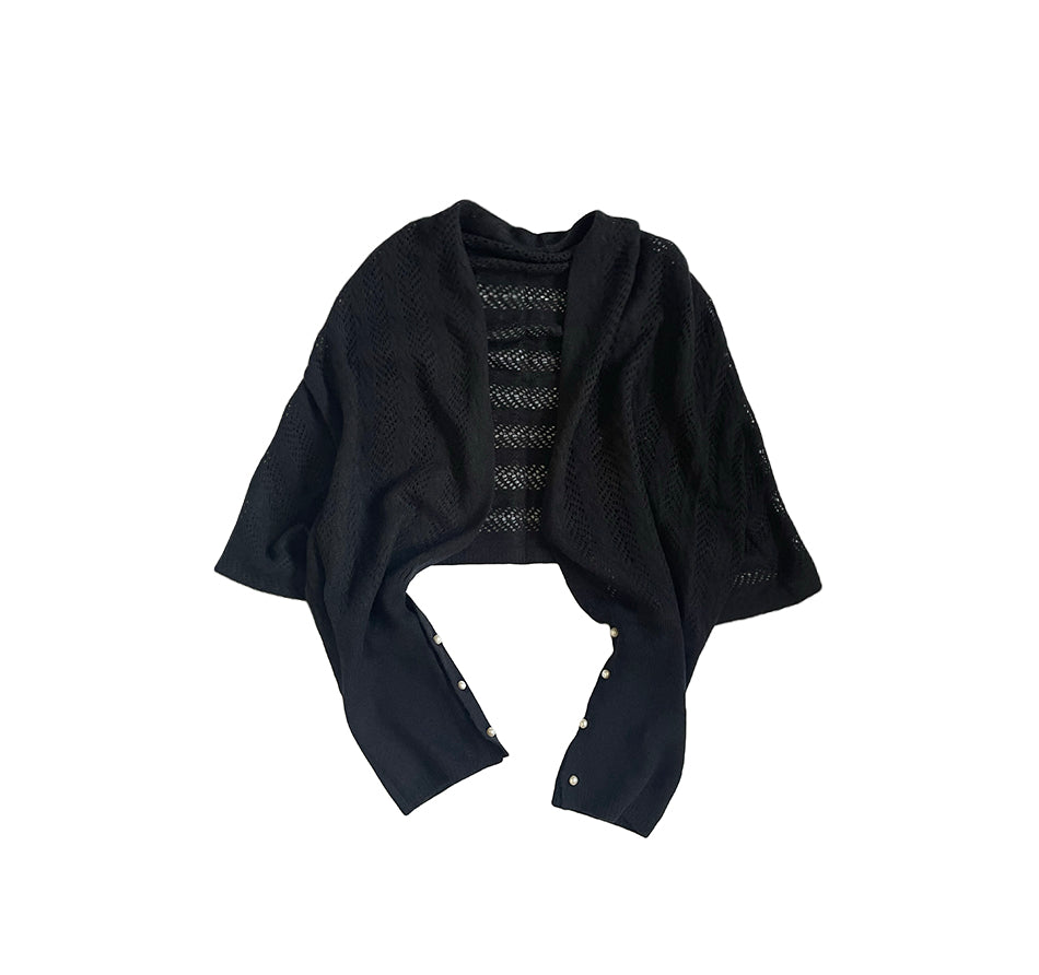 Seated styling: model wearing a cashmere cape as a scarf, sleeves buttoned for a neat, polished look.