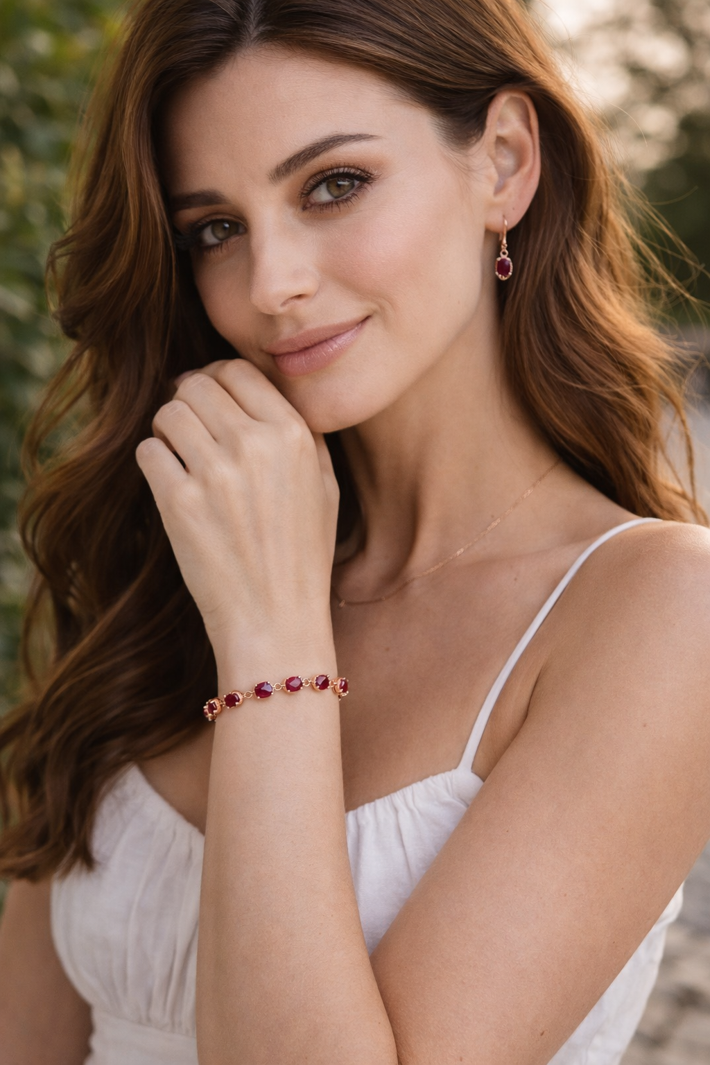 Ruby red oval tennis bracelet in gold plated 925 sterling silver on white background, luxury gemstone jewellery close-up
