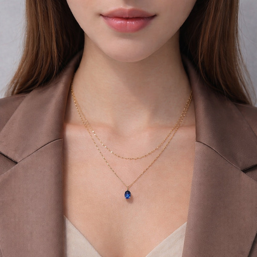 Minimalist blue sapphire necklace photographed on white background, fine gemstone jewellery for women