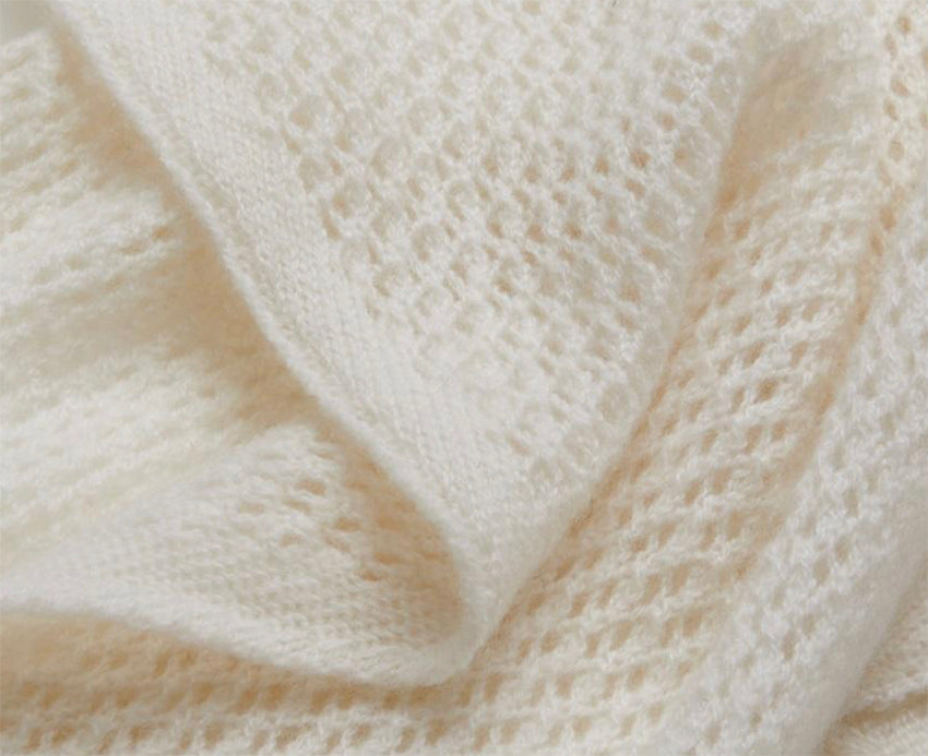 Detailed close-up of the premium knitted texture and luxurious softness of Moda de la Maria's 100% pure white cashmere scarf, handcrafted using the finest natural cashmere fibres.