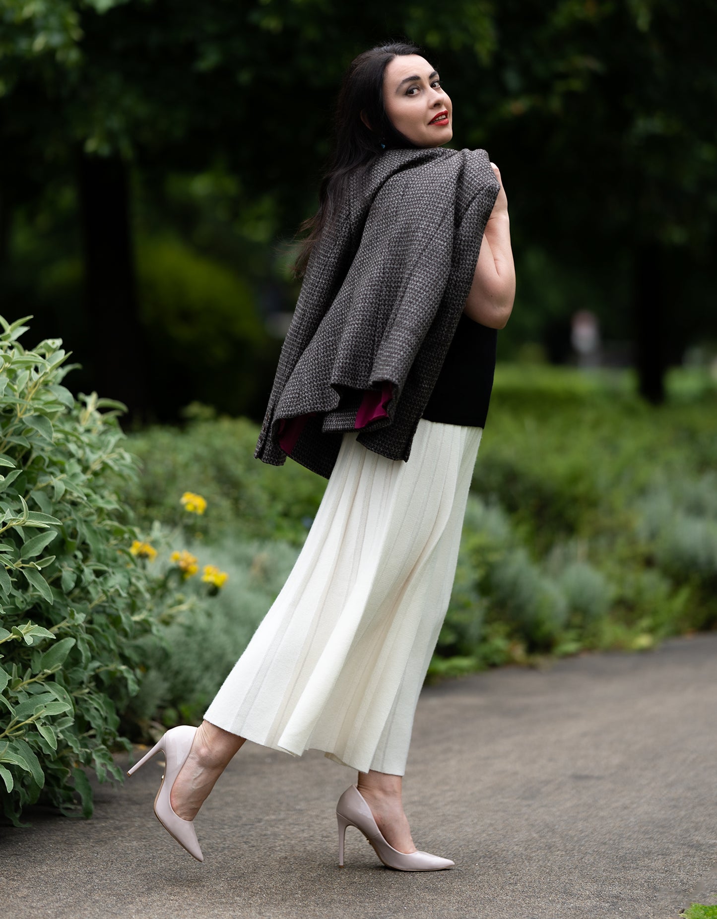 Model wearing organic cashmere skirt styled with matching knitwear for timeless sophistication.