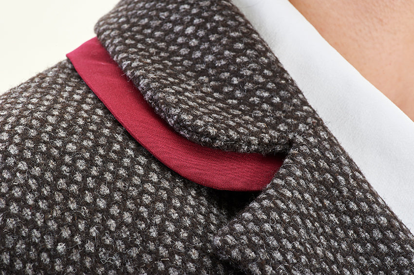 Close-up of detachable silk collar and button detailing on wool coat