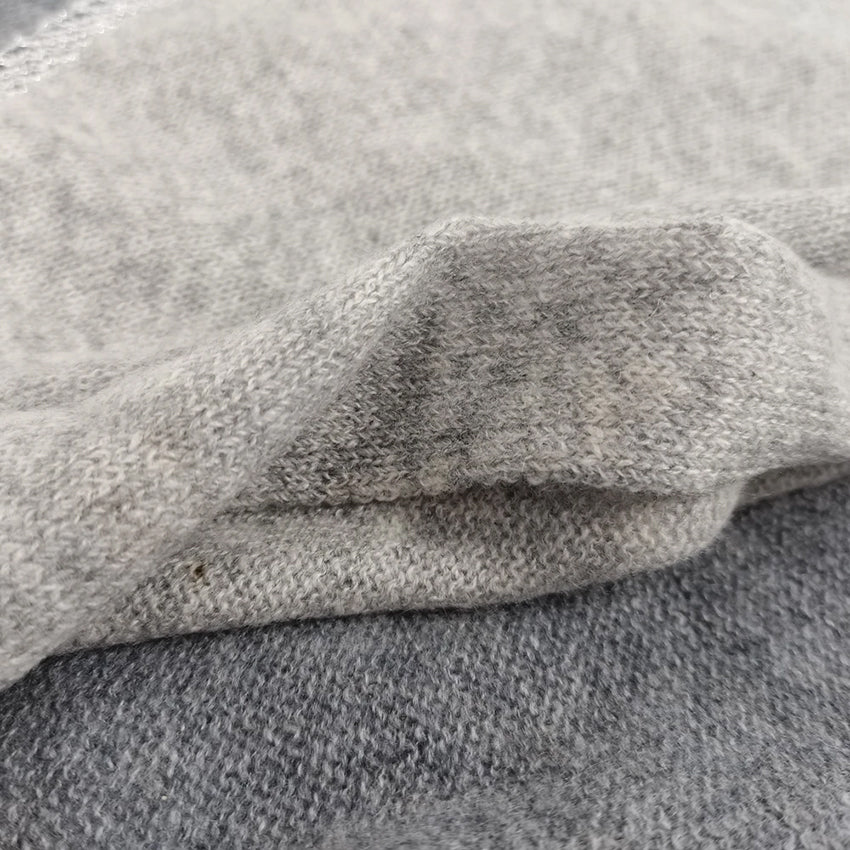Close-up of Moda de la Maria 100% pure cashmere colour-block pashmina scarf in charcoal grey, light grey and cream, highlighting the soft knitted texture.