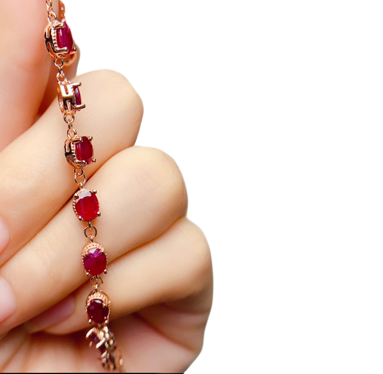 Natural ruby triangle-cut bracelet in 18K rose gold plated 925 silver, shown held in hand for scale.