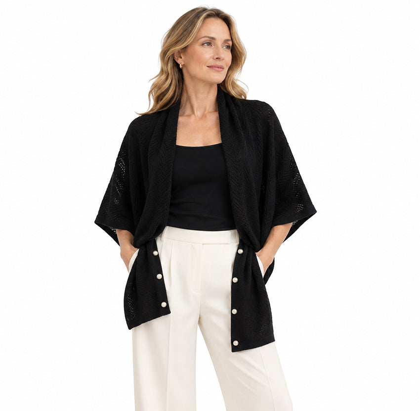 Woman wearing black pure cashmere convertible scarf cape with openwork knit and pearl button details