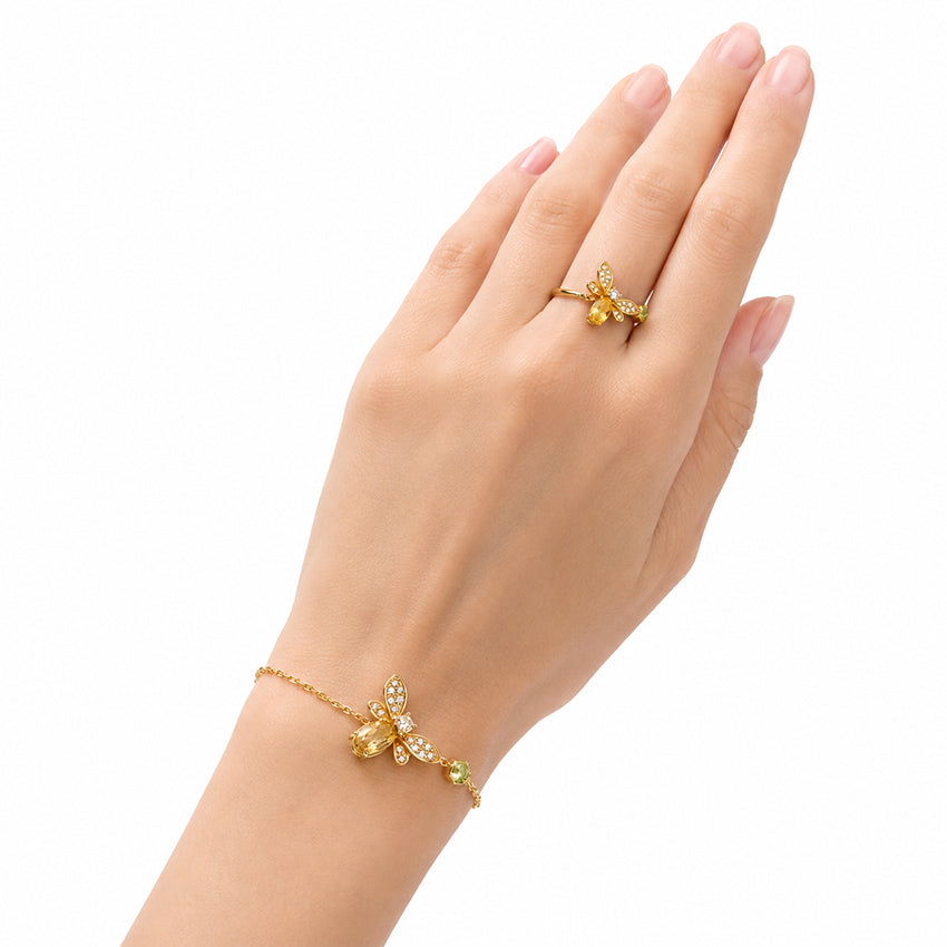 Gold-plated sterling silver bee ring with citrine and peridot styled on a model's hand
