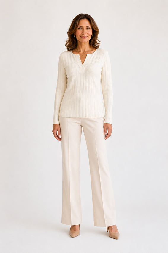 Elegant cream ribbed-knit top styled with tailored trousers, full-length front view.