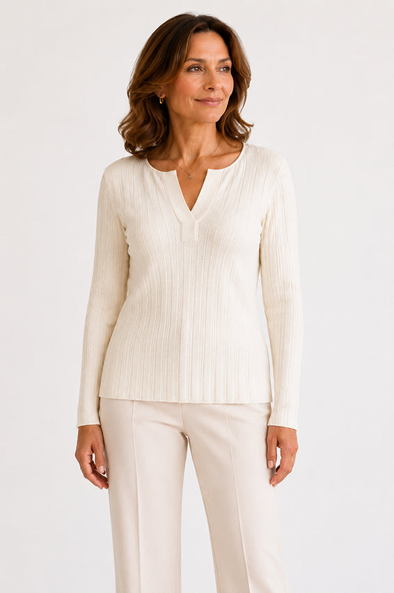 Side profile of cream ribbed knit top showing the flattering silhouette and fit.