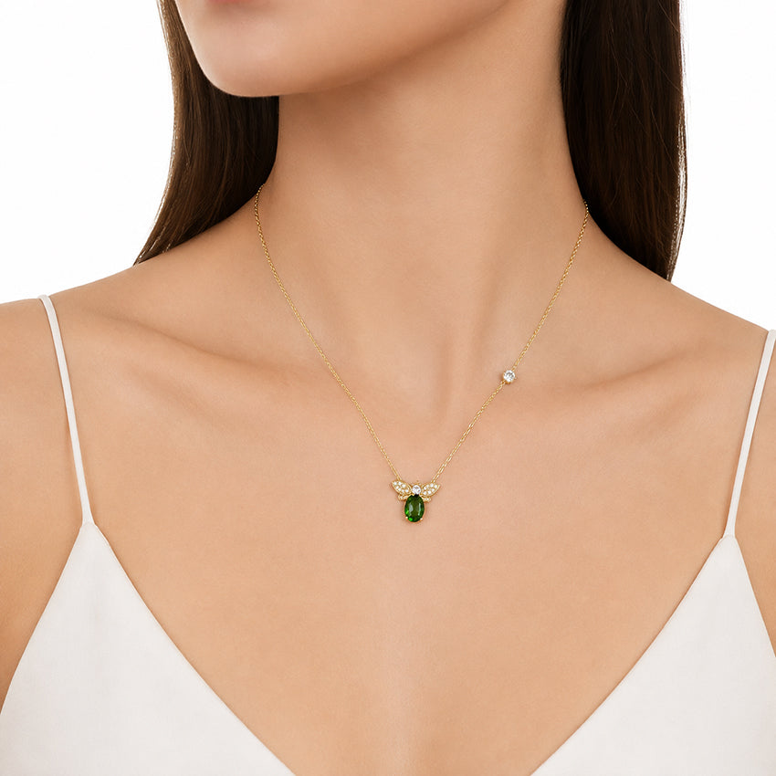 Close-up of the Moda de la Maria Natural Green Diopside Bee Necklace featuring a vivid green gemstone, pavé zirconia wings and fine gold vermeil chain.