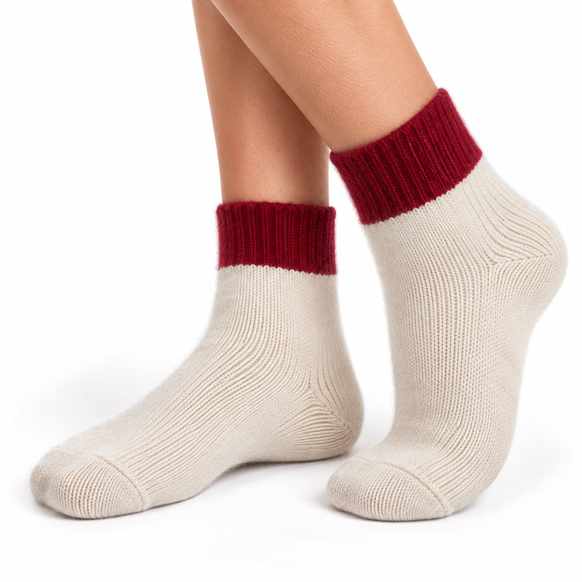 Women's ivory cream pure cashmere ankle socks with deep red ribbed cuffs by Moda de la Maria, shown worn on the feet.