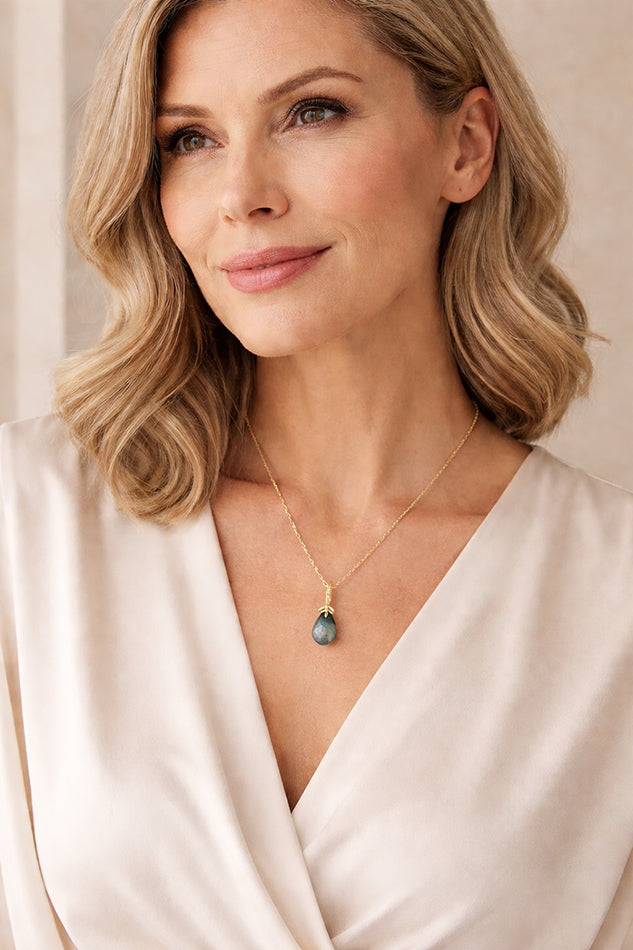 Minimalist labradorite pendant necklace in gold-plated sterling silver worn by an elegant woman, delicate fine chain jewellery for timeless womenswear.