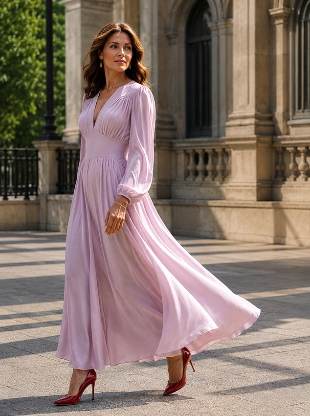 Elegant lavender silk maxi dress with a deep V-neckline and flowing skirt worn by a mature brunette model on a white background. 
