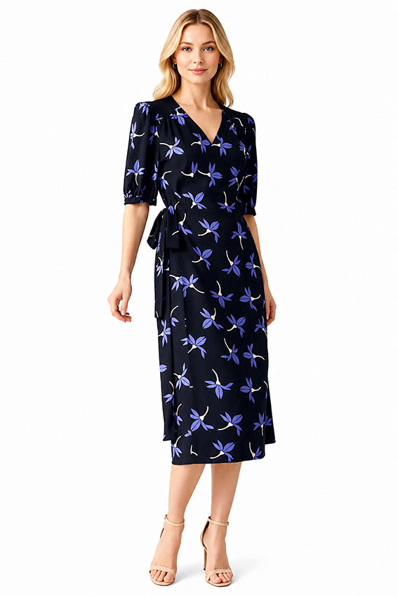 Elegant women’s mid-length wrap dress in dark navy silk-inspired fabric with delicate lavender floral print and feminine silhouette.
