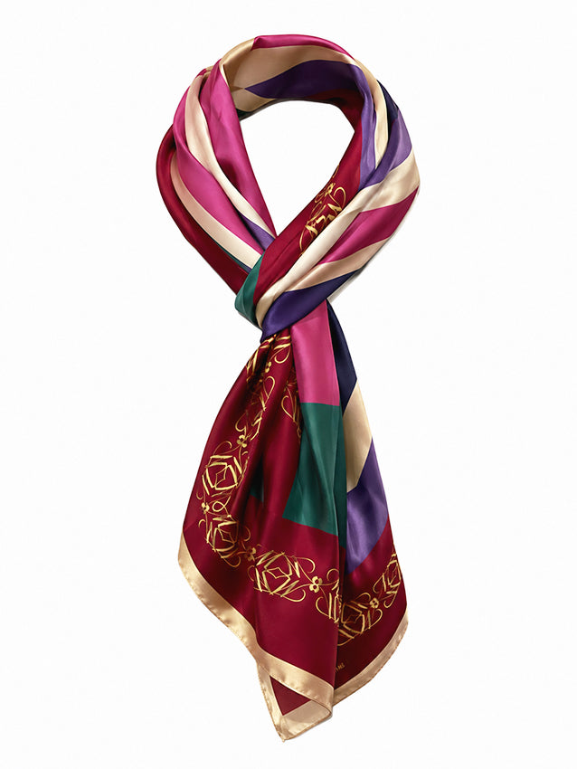 Luxury silk scarf with burgundy, pink, cream and emerald geometric print photographed on a clean white background for sustainable luxury womenswear by Moda de la Maria.