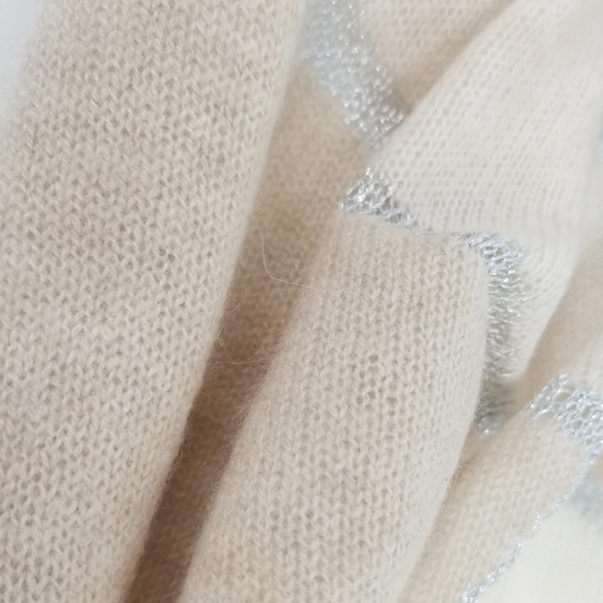 Detailed close-up of a Moda de la Maria luxury cashmere pashmina scarf in cream and taupe, revealing the fine knit construction and natural cashmere texture.