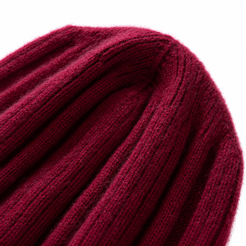Close-up of dark burgundy pure cashmere beanie showing the soft ribbed knit texture