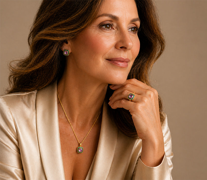 Sophisticated mature model wearing gold jewellery set with purple gemstone necklace, earrings and ring by Moda de la Maria, timeless luxury styling for women over 40.
