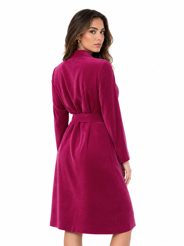 Magenta silk dress with elegant buckle belt and long sleeves on a sophisticated brunette model against a white studio background
