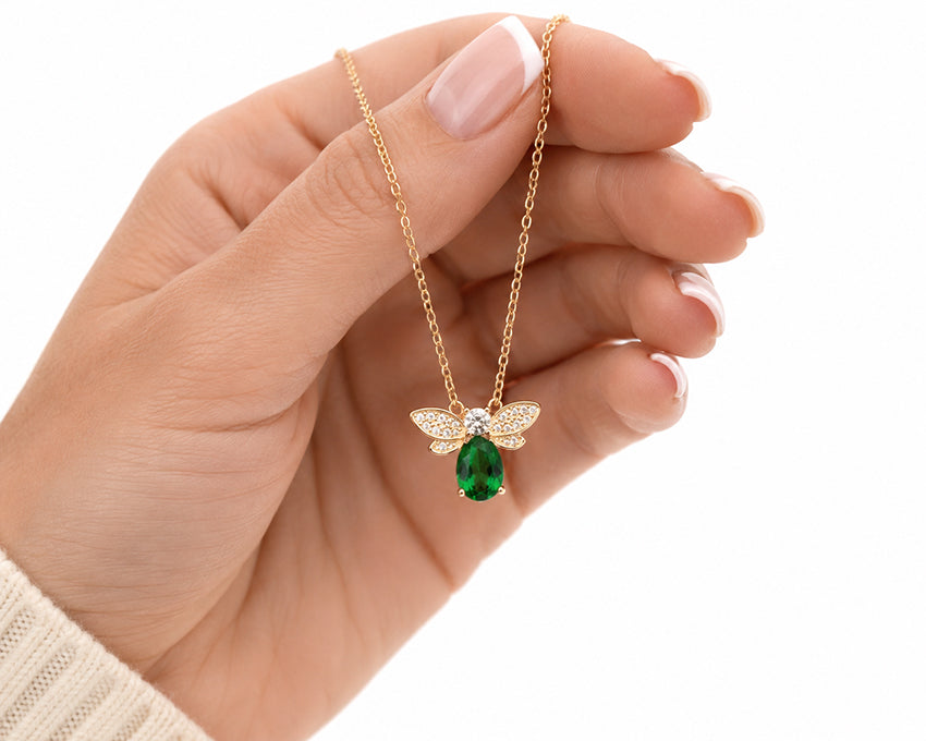 Close-up of the Moda de la Maria Natural Green Diopside Bee Pendant Necklace highlighting the sparkling zirconia wings, natural green diopside gemstone and 18ct gold vermeil finish.
