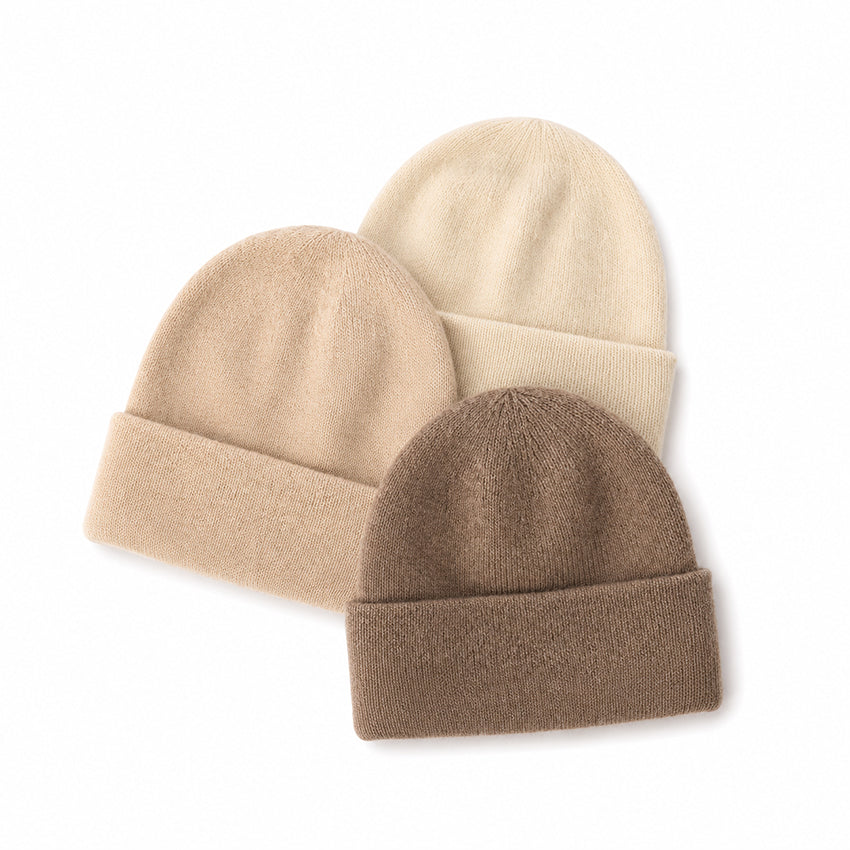 Luxury women's pure cashmere beanie hat collection by Moda de la Maria in cream, oatmeal and taupe, showcasing fine knitted cashmere and timeless winter styling.