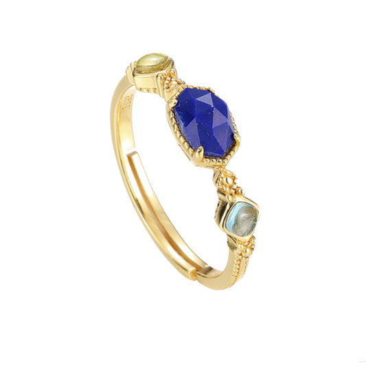 Hand wearing gold plated sterling silver ring with lapis lazuli centre stone and labradorite gemstone