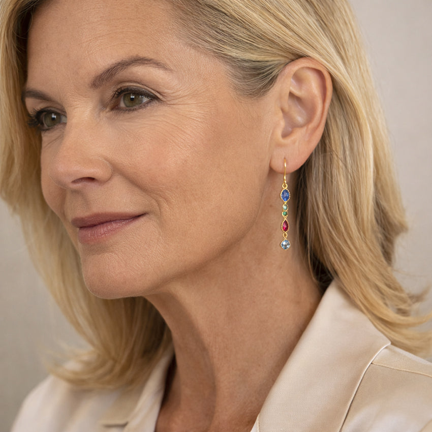 Multicolour cubic zirconia drop earrings in 18K gold plated sterling silver worn by a mature woman, elegant long dangle jewellery
