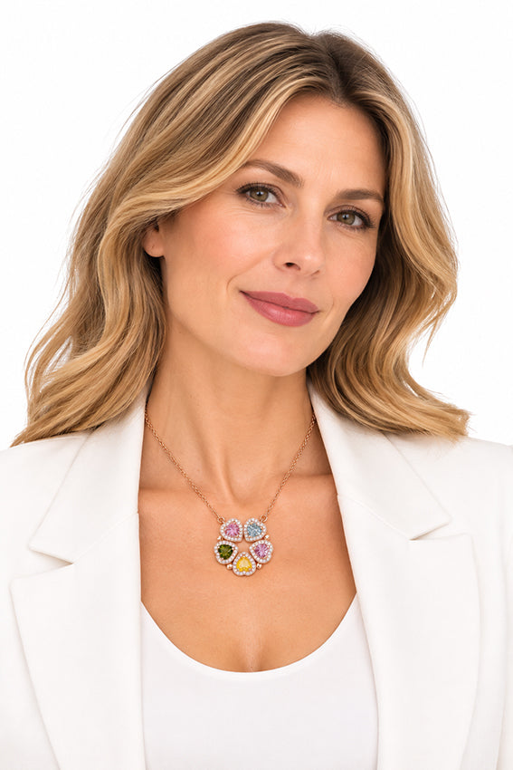 Woman wearing Moda de la Maria multicolour heart gemstone necklace in rose gold, styled with a white blazer.