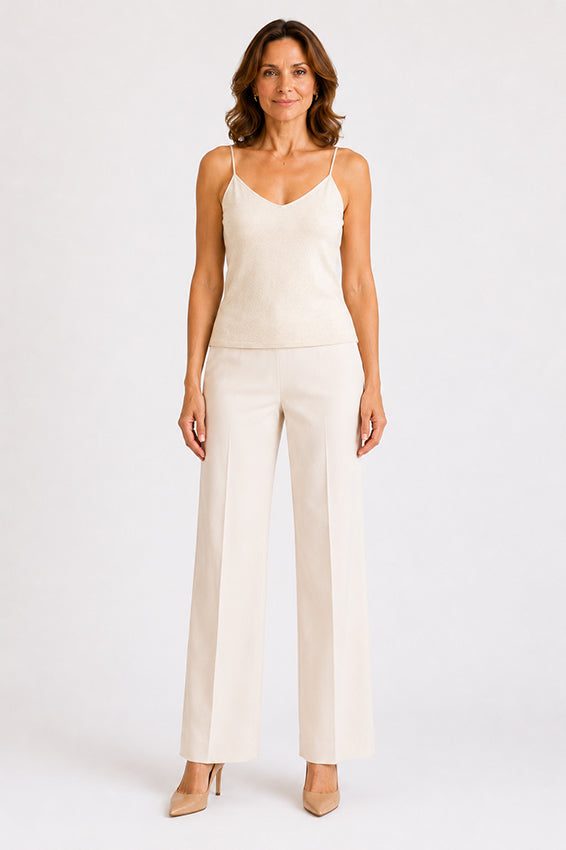 Front view of a luxury organic cashmere camisole in natural ivory worn by a woman
