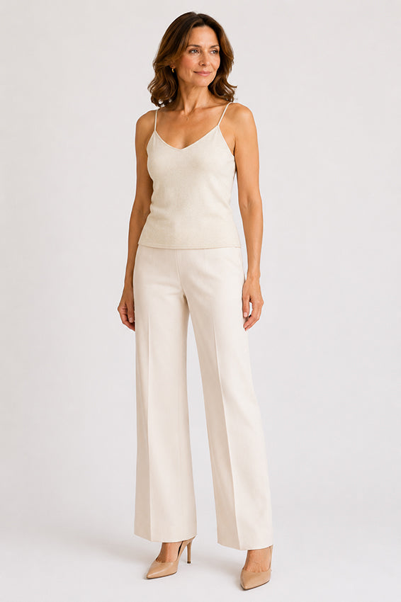 Woman wearing a luxury organic cashmere camisole in natural ivory, front three-quarter view