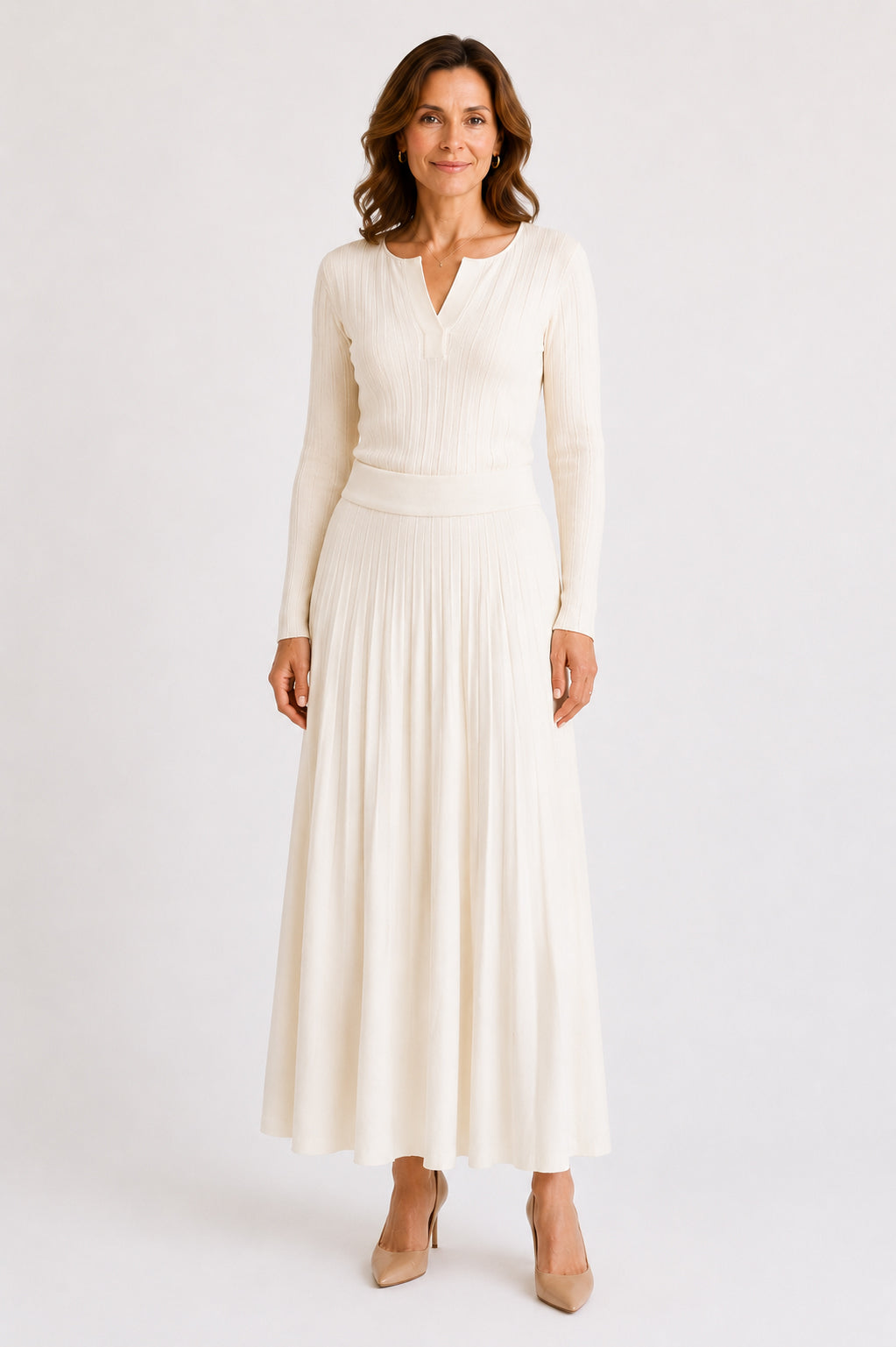 Luxury organic cashmere ivory knitted skirt front view on a mature female model, showcasing the timeless A-line silhouette and premium knit texture.