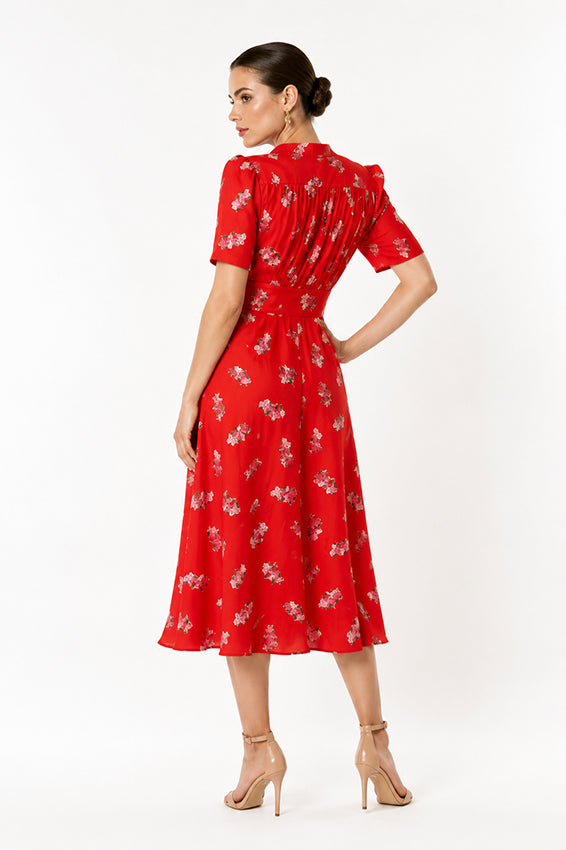 Luxury red floral midi dress with flattering waistline and feminine silhouette photographed against a white background.