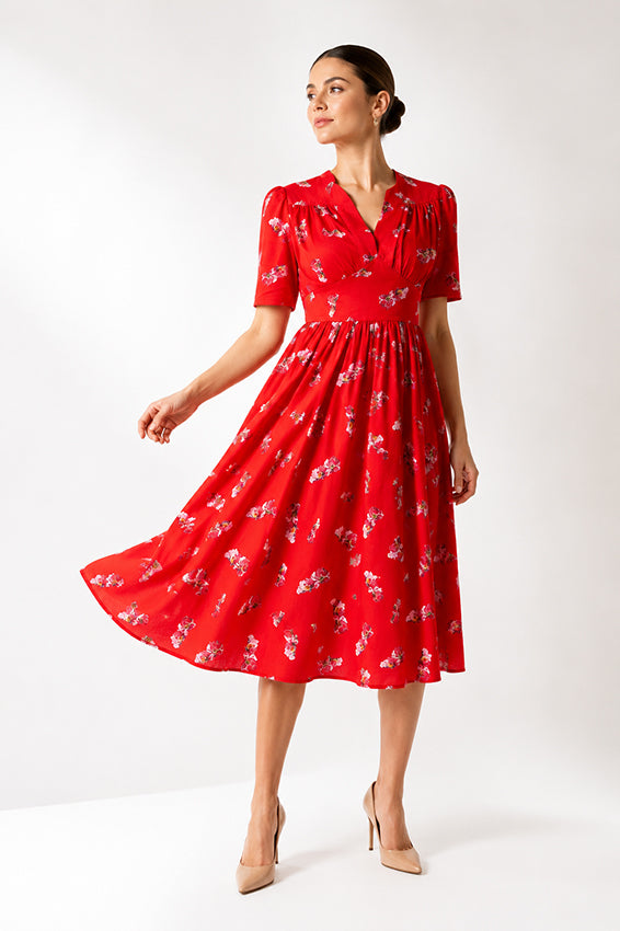 Sophisticated red floral midi dress styled on an elegant model in a minimalist luxury studio setting.