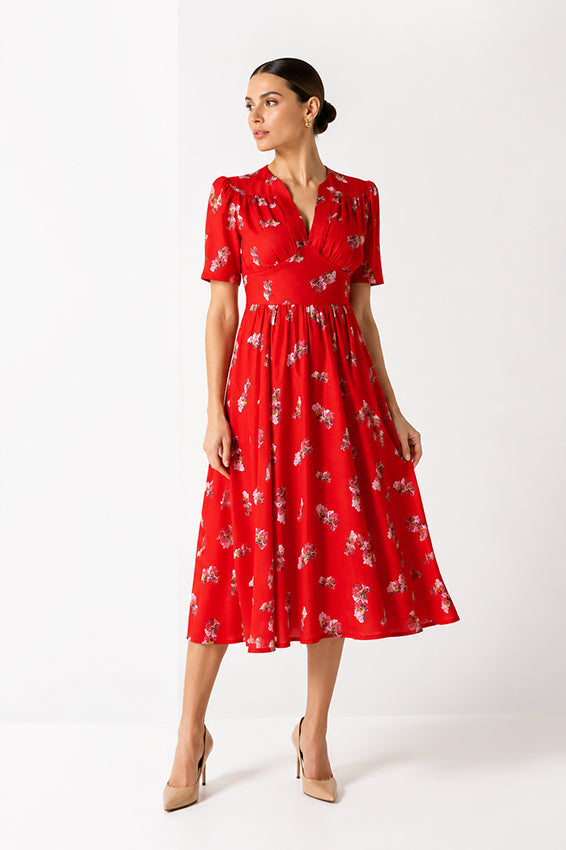 Luxury womenswear editorial featuring red floral midi dress with flowing silhouette and timeless elegance.
