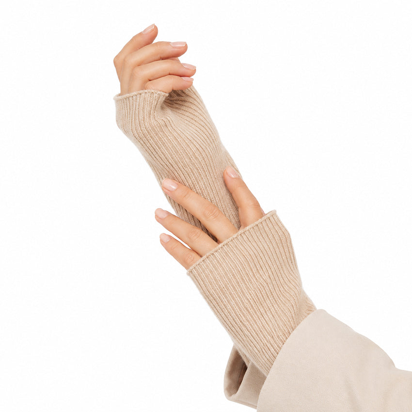 Oatmeal 100% cashmere fingerless gloves worn on women's hands, showing the soft ribbed knit texture