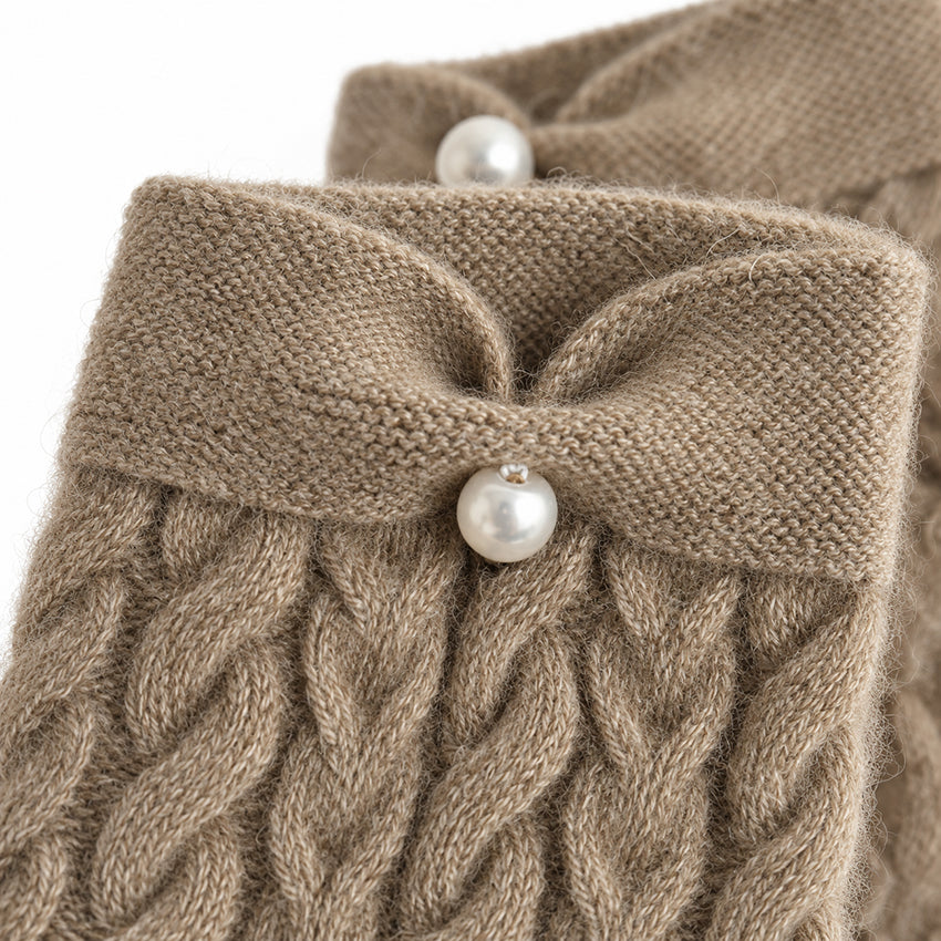Close-up of taupe cashmere fingerless gloves showing soft cable knit texture and pearl detail by Moda de la Maria.