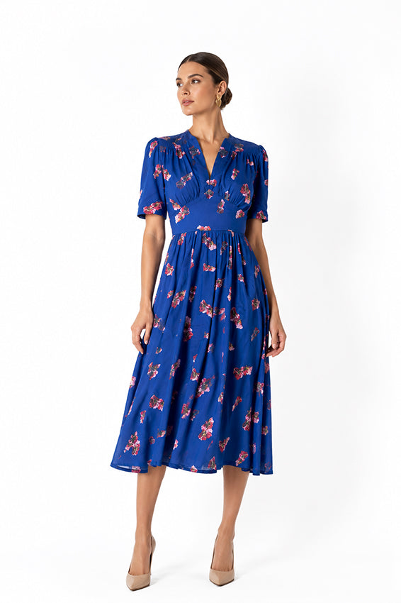 Editorial portrait of a luxury blue floral midi dress with romantic floral print and elegant, feminine styling.
