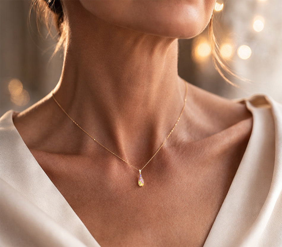 Victorian inspired opal enamel pendant necklace in 925 sterling silver with gold vermeil plating, featuring a delicate minimalist teardrop opal design on fine chain, worn on elegant mature model

