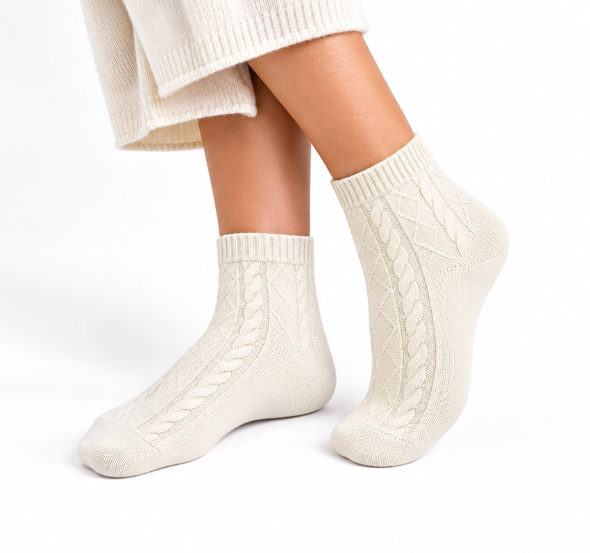 White pure cashmere cable-knit ankle socks for women, modelled on feet against a white background by Moda de la Maria.