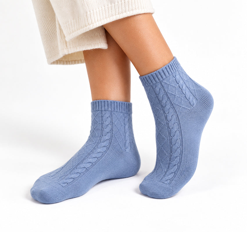 Women’s blue 100% cashmere cable-knit ankle socks worn on model against a white background